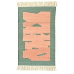 Handwoven light green cotton area rug with peachy abstract design and fringed edges, perfect for a boho-inspired living room or bedroom.