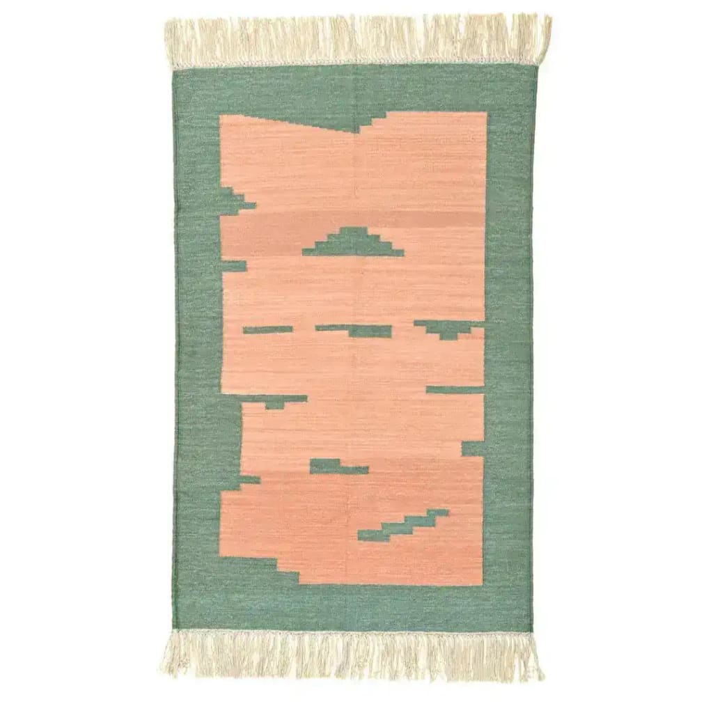 Handwoven light green cotton area rug with peachy abstract design and fringed edges, perfect for a boho-inspired living room or bedroom.