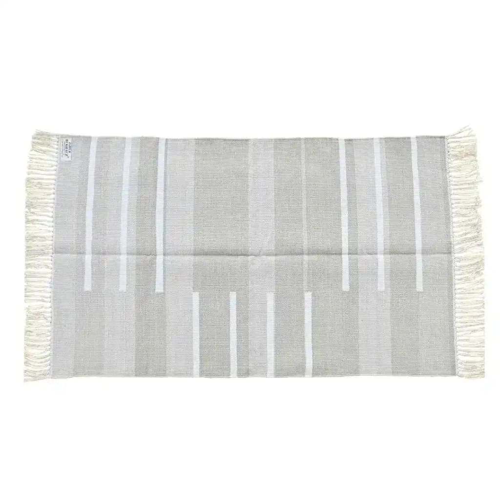 A handwoven minimalistic gray cotton area rug featuring fringes on both ends. This large living room rug, sized 8x10, showcases a subtle striped pattern, perfect for adding a boho touch to any living room decor.