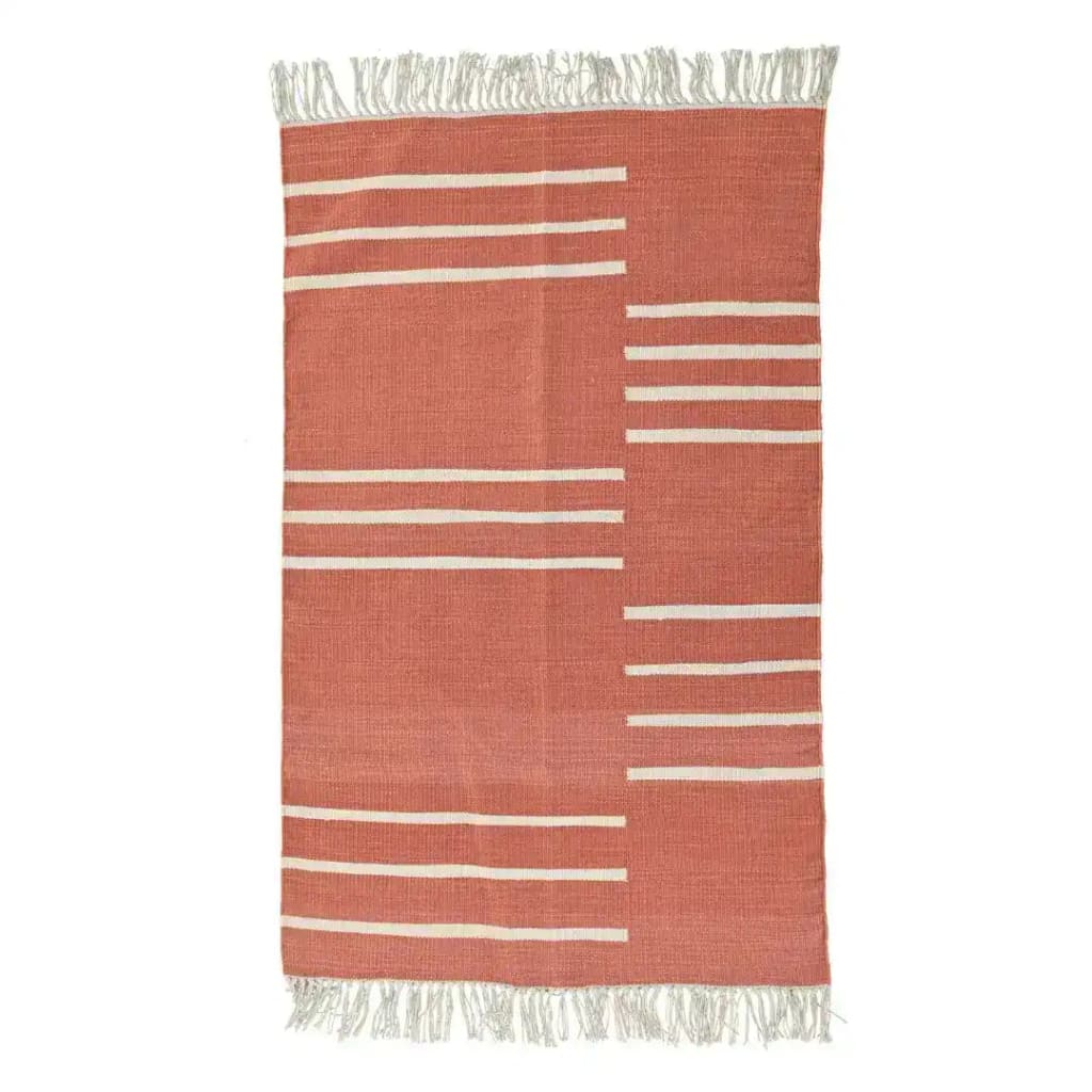 A handwoven orange and white minimalistic cotton area rug with fringes, perfect for adding a boho touch to a dining room or office. This elegant dining table rug showcases a simple yet stylish design suitable for any modern space.