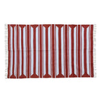 A handwoven red and white cotton area rug with accent stripes, perfect for enhancing living room and dining room spaces. This large boho rug features fringed edges, adding a stylish touch under a dining table.