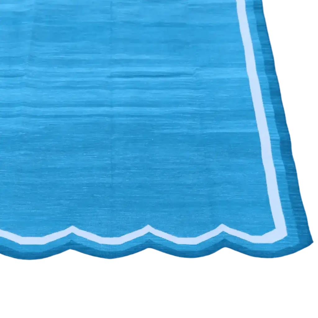 A beautifully handwoven scalloped cotton area rug in blue and white, perfect for adding a touch of vintage charm to your bedroom. The large boho rug features intricate patterns and soft textures, making it an ideal choice for bedroom area rugs and enhancing the cozy ambiance of your space.