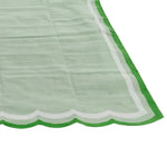 A beautifully handwoven scalloped cotton area rug in light green, perfect for adding a vintage touch to your living room or bedroom. The rug features a unique scalloped edge with a vibrant green border, ideal for boho-inspired decor. This versatile cotton rug is an excellent choice for living room rugs 8x10, offering both style and comfort.