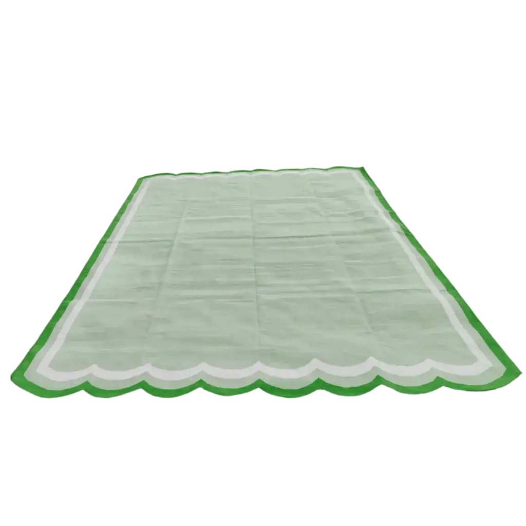 A beautifully handwoven scalloped cotton area rug in light green, perfect for adding a vintage touch to any living room or bedroom. This boho rug features a unique scalloped edge and soft texture, ideal for use as an 8x10 living room rug.