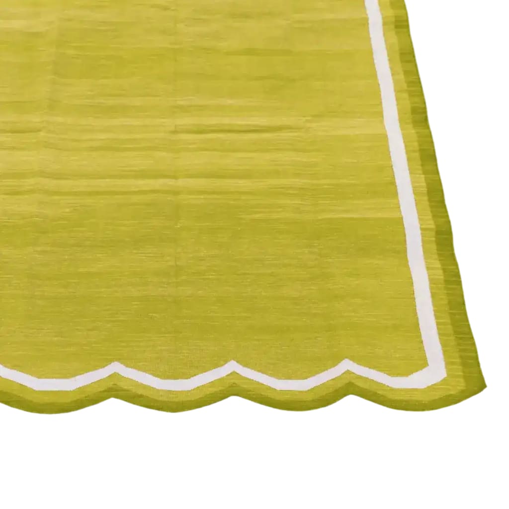 A vibrant lime green handwoven scalloped cotton area rug, perfect for adding a touch of boho charm to your living room or office. The vintage-inspired design features a delicate white scalloped border, making it an ideal choice for those seeking stylish rugs for living room or office spaces.