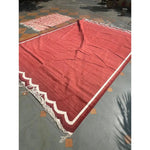 Handwoven scalloped cotton area rug in vibrant red, perfect for dining rooms or offices. This vintage boho rug features a detailed scalloped edge, making it an ideal choice for formal dining room settings or adding a touch of elegance to any space.