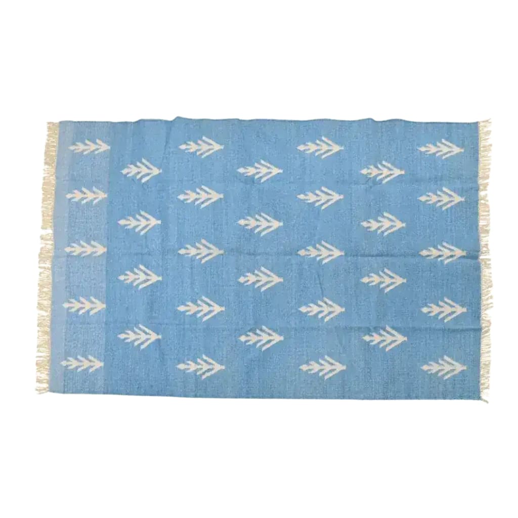 This is a beautifully handwoven white floral blue cotton rug, perfect for adding a touch of boho elegance to your living room. The large area rug features intricate white floral patterns on a soft blue background, complemented by delicate fringes on the edges. Ideal for those looking to enhance their space with a stylish and functional large area rug for living room settings.