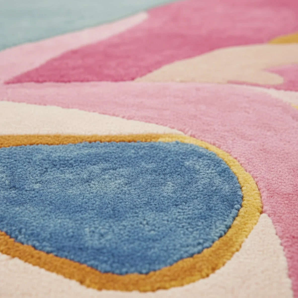 Close-up of a colorful geometric rug with pink, blue, yellow, and beige shapes.
