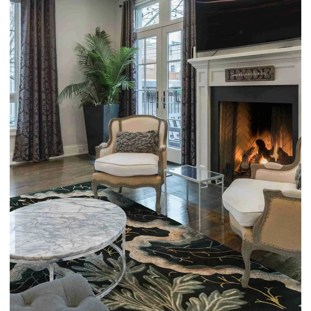 A luxurious living room featuring an elegant area rug with a floral pattern. The wool rug adds a touch of sophistication to the space, complementing the classic armchairs and marble coffee table. Ideal for enhancing both dining room and bedroom aesthetics.