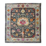 Charming Heirloom Petals Classic Hand Tufted Rug displaying a vintage floral design in rich, colorful tones on a dark background. This large 8x10 area rug is perfect for adding a touch of elegance to any living room. Made from high-quality wool, it's both a floral and vintage rug that enhances the ambiance of your space.