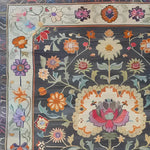 Close-up of the Heirloom Petals Classic Hand Tufted Rug, showcasing its intricate floral design. This wool rug features a vibrant mix of colors, ideal for adding a vintage touch to your living room. Perfect as a large area rug, it fits beautifully as an 8x10 living room rug.