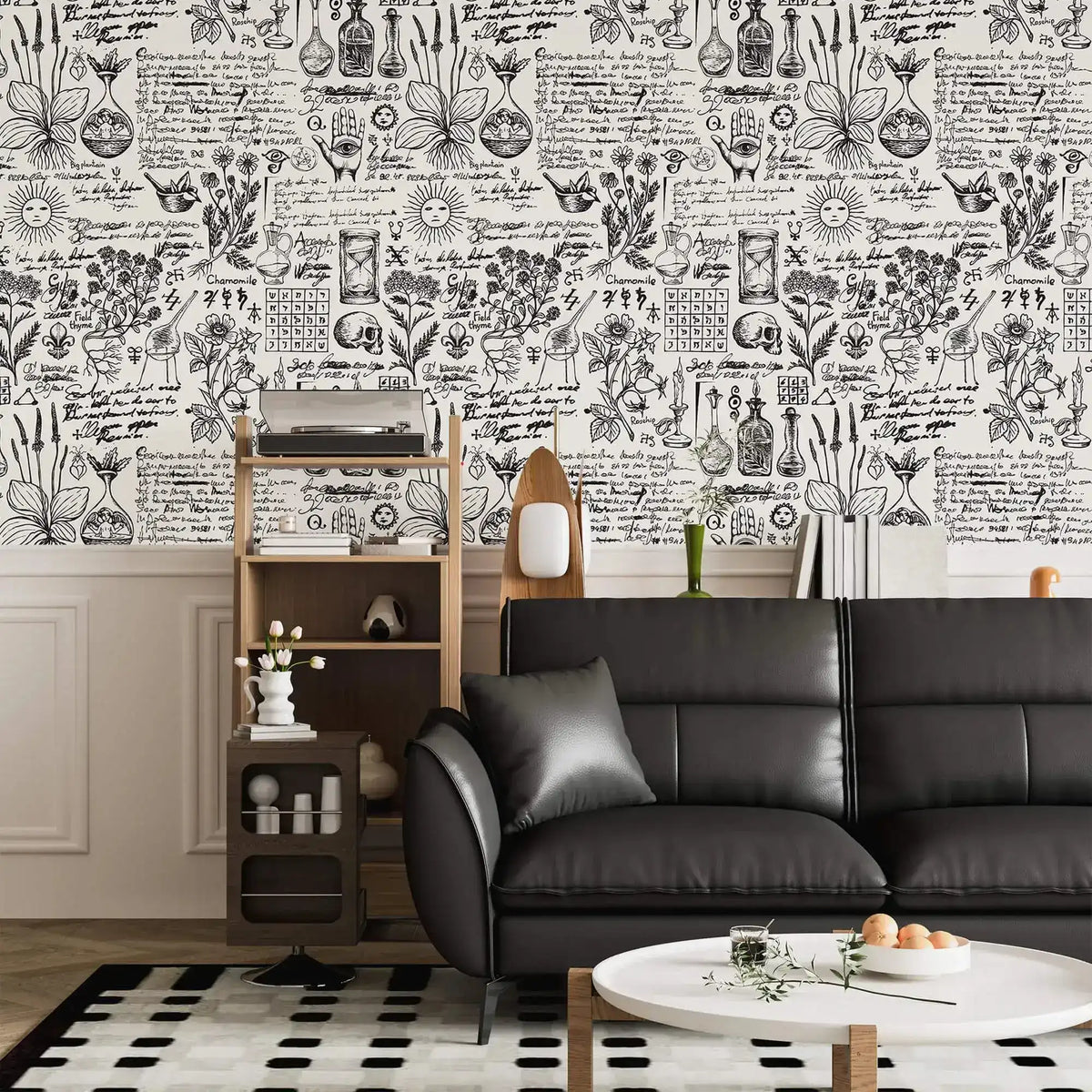 Herbal alchemy wallpaper in black and white above wainscoting with a black leather sofa and shelf