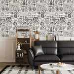 Herbal alchemy wallpaper in black and white above wainscoting with a black leather sofa and shelf