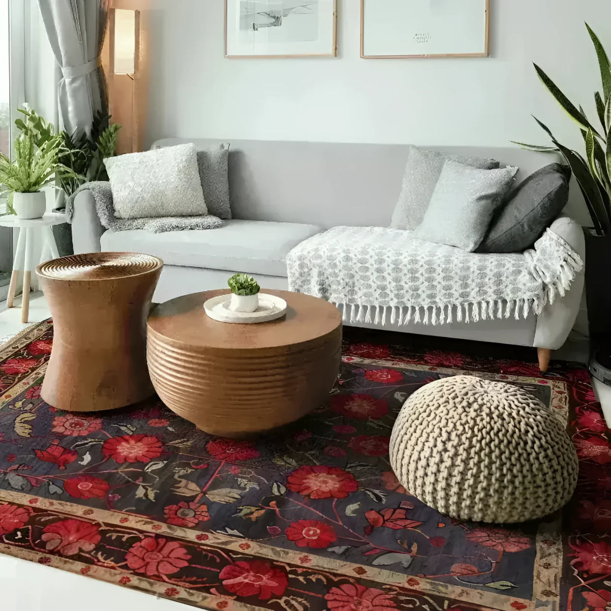A cozy living room featuring a Heritage Chic Hand Knotted Area Rug with a vintage Persian design. The floral rug showcases rich red and navy hues, adding a touch of elegance to the modern setting. Perfect for rugs for living room setups, the rug complements a gray sofa and wooden coffee tables.