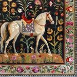 Elegant Horse & Blossom Wool Hand Knotted Area Rug featuring a majestic white horse surrounded by vibrant floral patterns. This exquisite square area rug is perfect for adding a touch of Persian-inspired charm to your dining room or office. Ideal for those seeking luxurious wool rugs for living room and dining room spaces.