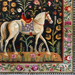 Elegant Horse & Blossom Wool Hand Knotted Area Rug featuring a majestic white horse surrounded by vibrant floral patterns. This exquisite square area rug is perfect for adding a touch of Persian-inspired charm to your dining room or office. Ideal for those seeking luxurious wool rugs for living room and dining room spaces.