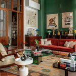 A stylish living room showcasing a Horse & Petal Tapestry Hand Knotted Area Rug. This elegant 8x10 floral rug features intricate patterns reminiscent of Persian rugs, enhancing the cozy ambiance of the space. The rug beautifully complements the vibrant decor and eclectic furniture, making it a perfect addition to living room area rugs collections.