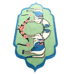 A vibrant hand-tufted rug featuring an artistic design of two stylized horses in blue and white, set against a green backdrop with floral accents. This wool area rug is perfect for adding a boho touch to your dining room or living room, and is a great choice for those seeking large area rugs with character.