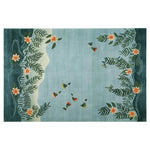 The Humming Haven Knotted Wool Rug, a large area rug perfect for living rooms, features a serene design with hummingbirds and floral patterns on a soft blue background, creating a tranquil atmosphere.