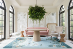 Modern living room with pink sofa, round table, and decorative blue rug.