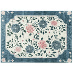 A beautifully designed area rug featuring an intricate floral pattern with vibrant pink and blue flowers against a cream background. This wool rug adds elegance to large living room spaces, perfect for enhancing the decor with its lush, hand-tufted texture.
