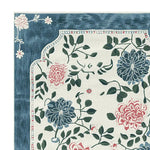 Close-up of the Hushed Bloom Tangle Hand Tufted Area Rug showcasing its intricate floral design. This wool rug features vibrant blue and pink flowers with lush green leaves, making it ideal for large living rooms seeking an elegant touch. Perfect for adding a splash of nature to your area rugs for living room collection.