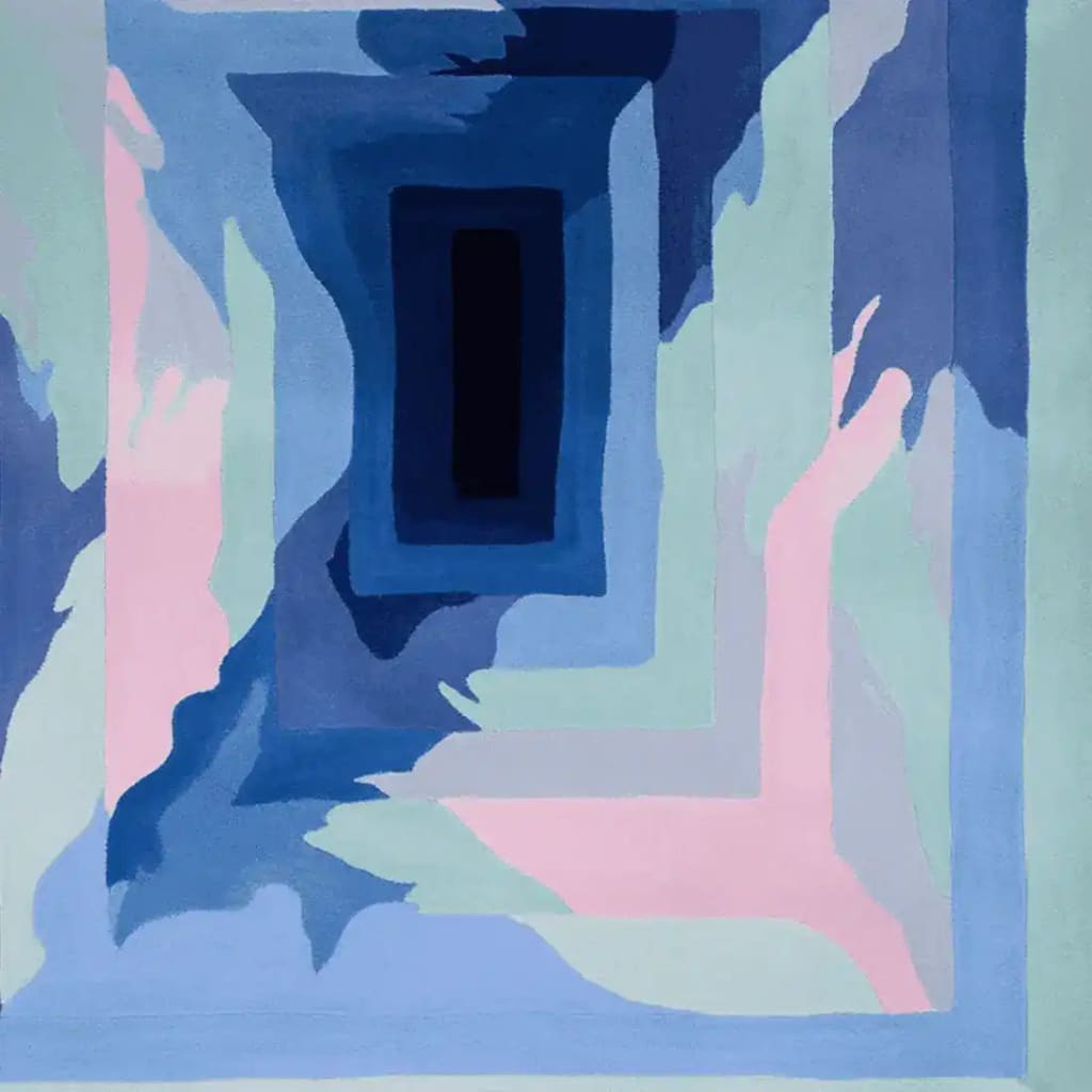 A contemporary area rug featuring an abstract design in shades of blue, pink, and green. This wool rug showcases a visually striking pattern, perfect for adding a modern touch to any living room.