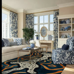 Contemporary living room featuring an Illusionary Prowess Hand Tufted Area Rug with abstract patterns in vibrant colors. This wool rug adds a touch of modern elegance, perfect for enhancing the style of any bedroom or living room area.