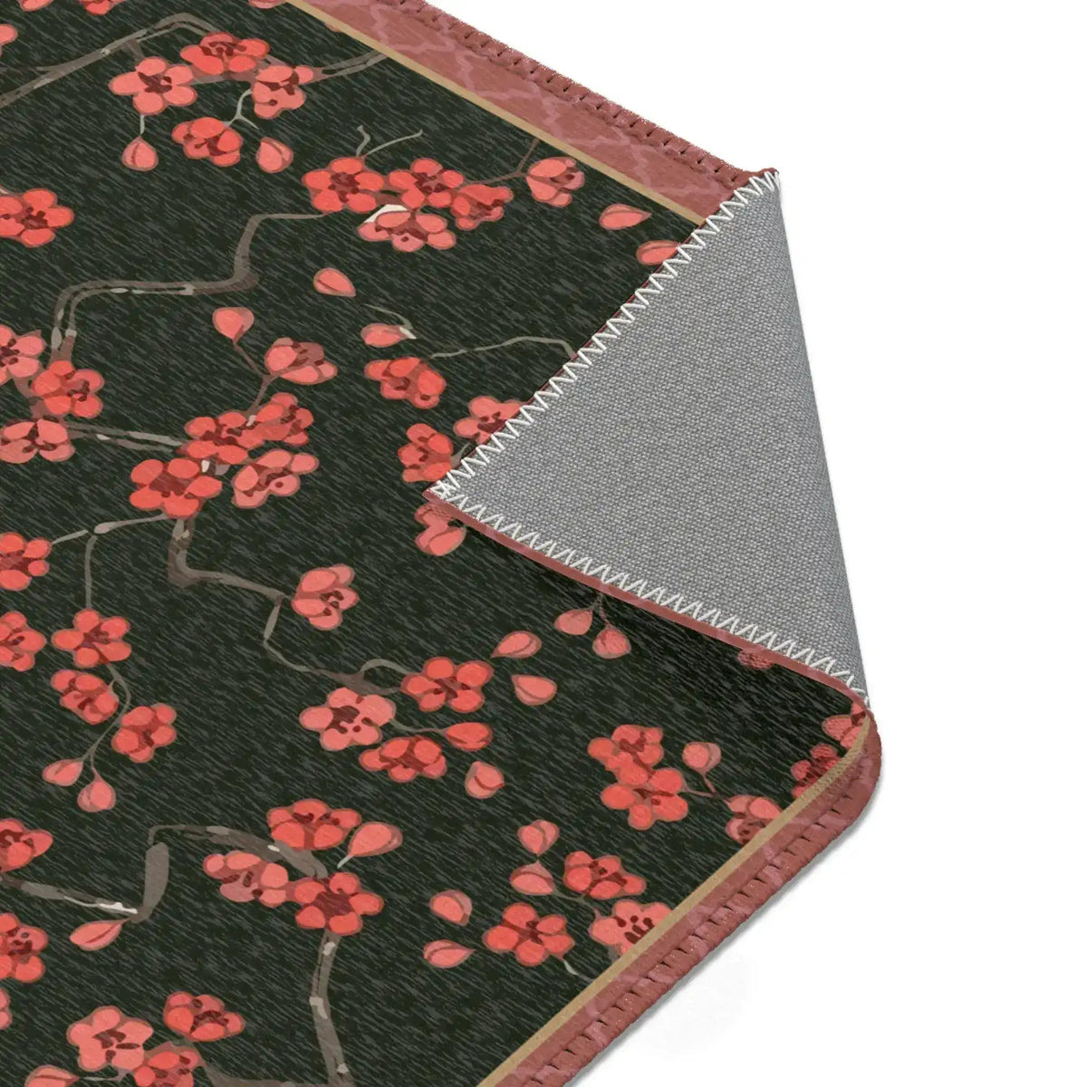 Imperial arch bloom rug corner folded to show grey non-slip backing and coral blossom face