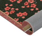 Imperial arch bloom rug with corner rolled up, coral blossoms on green with grey backing and pink trim