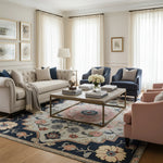 Living room with beige sofa, blue armchair, and pink chair on a floral rug.
