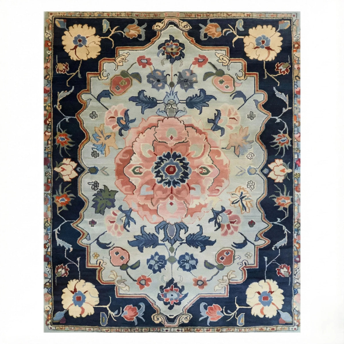 Traditional hand-tufted rug with a navy border, sage field, and a large pink floral medallion in classic Persian style