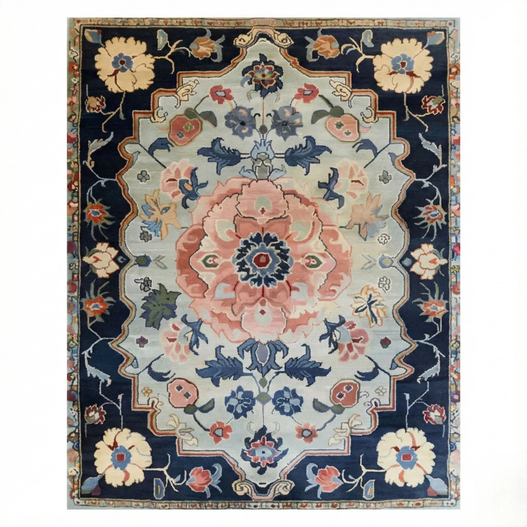 Traditional hand-tufted rug with a navy border, sage field, and a large pink floral medallion in classic Persian style