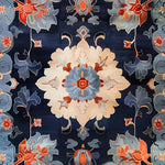 Close-up view of the Imperial Garden Hand Tufted Area Rug, showcasing its intricate vintage floral design with vibrant blue and orange hues. This wool rug is ideal for adding a touch of elegance to offices or as a large area rug for living rooms.