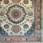 The Imperial Tapestry Hand Knotted Area Rug showcases an intricate floral and vintage design, reminiscent of classic Persian rugs. This stunning living room area rug measures 8x10 and features a rich blend of blues, reds, and creams, perfect for adding a touch of elegance to any space.