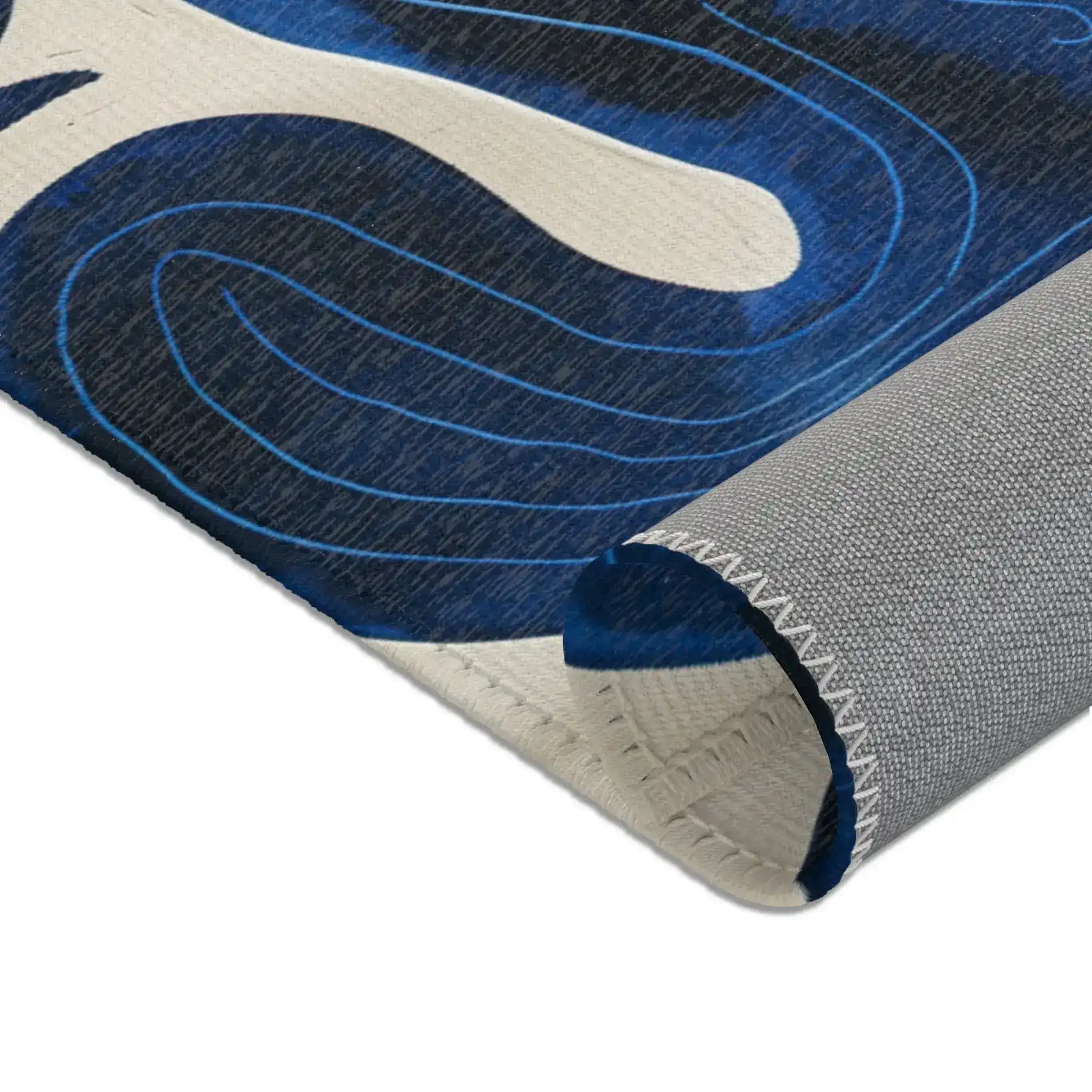 Indigo Desert Dreams rug corner close-up fold showing indigo cactus spiral motif and grey backing texture detail