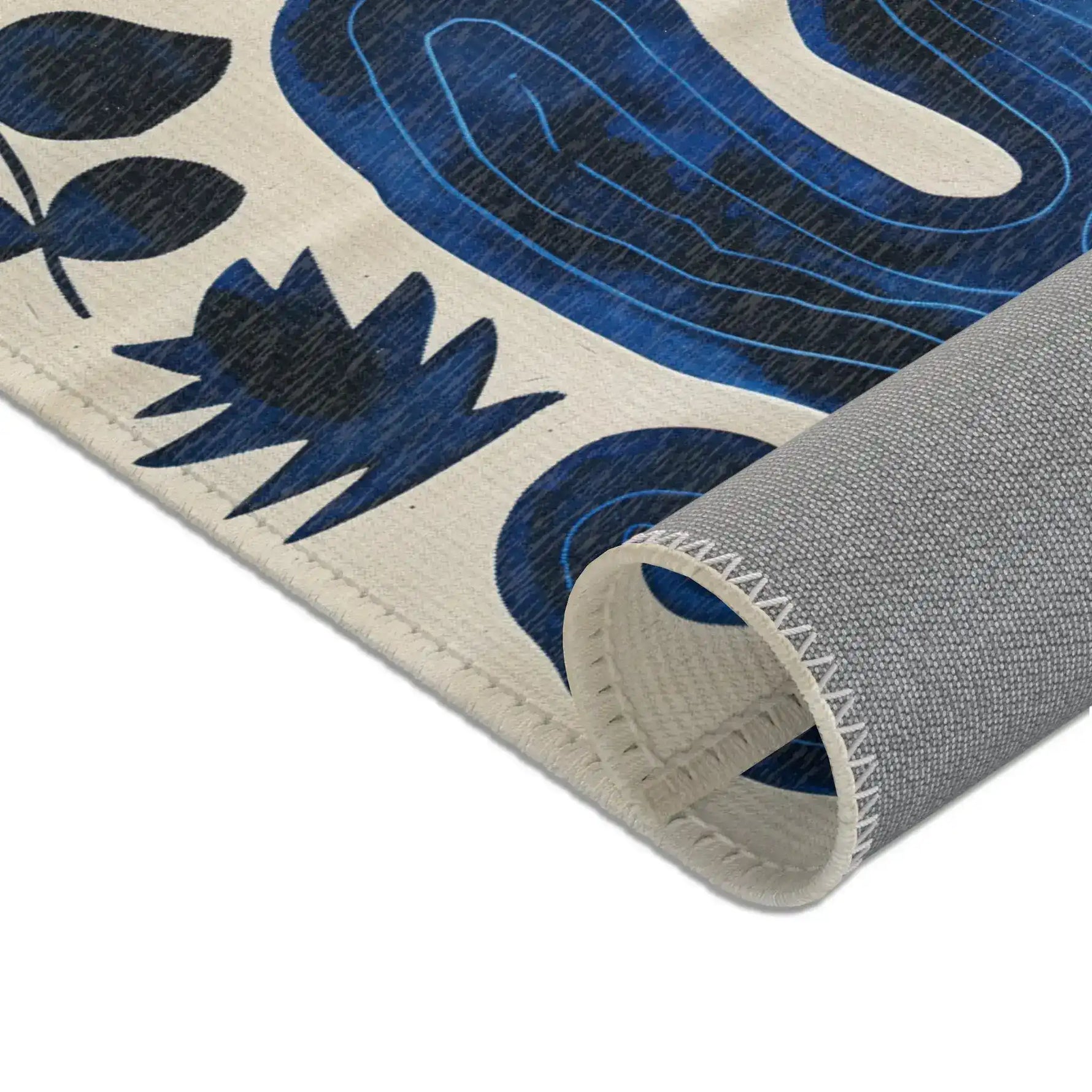 Indigo Desert Dreams rug edge rolled corner showing grey backing and blue leaf cactus pattern detail close-up
