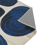Indigo Desert Dreams Abstract Botanical Rug corner folded showing indigo spiral motif on cream and grey backing edge