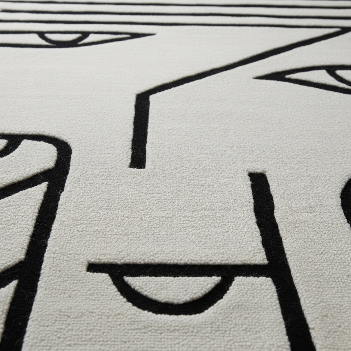Close-up of a textured rug with black line art on a light gray background