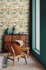 Insect garden wallpaper in cream with butterflies and beetles beside a teal wall and carved wood cabinet