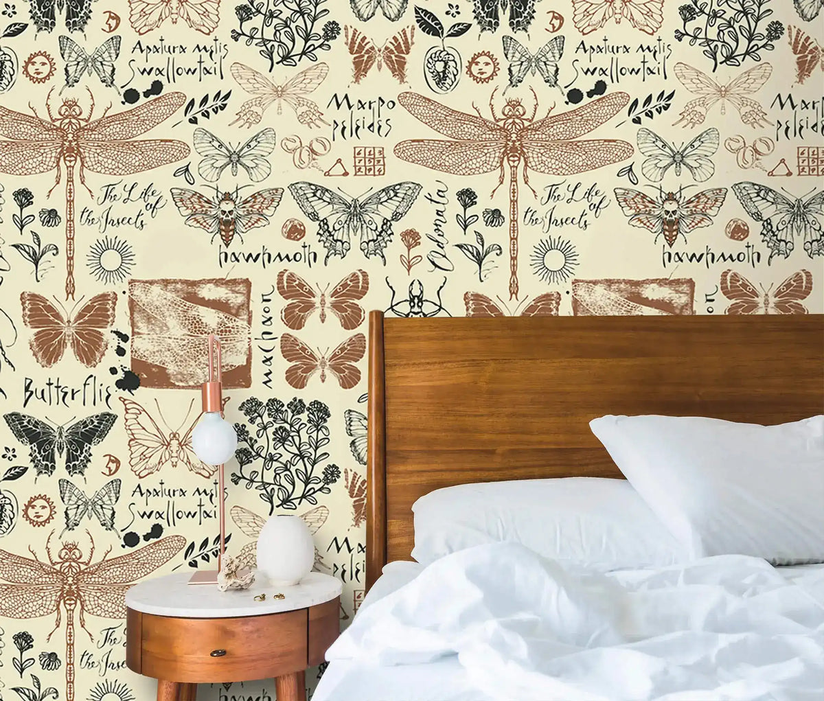 Close-up of insect garden wallpaper with detailed dragonflies and butterflies on cream beside a wood bed headboard