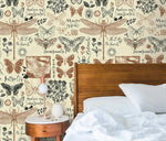 Close-up of insect garden wallpaper with detailed dragonflies and butterflies on cream beside a wood bed headboard