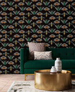Insect Harmony Wallpaper covering full wall behind green velvet sofa; beetles and moths in amber and green on black