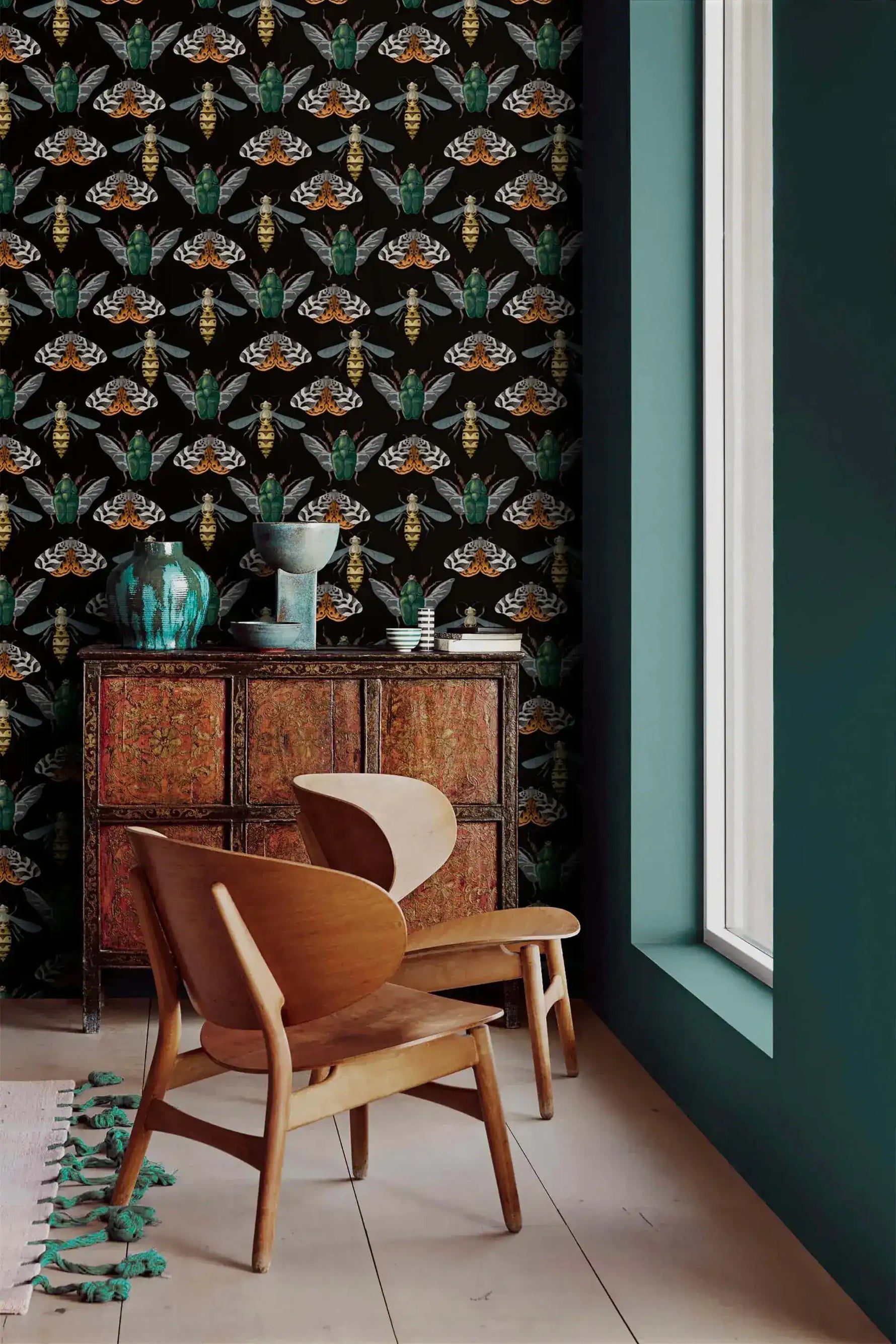 Insect Harmony Wallpaper styled with antique sideboard and sculptural wood chair; beetles and moths on black