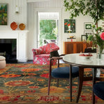 This inviting living room features an exquisite Intricate Bloom Wool Hand Knotted Area Rug, showcasing a vibrant floral pattern that complements the vintage decor. Perfect as a square area rug for both bedroom and living room settings, this wool rug blends traditional Persian rug aesthetics with a modern twist, enhancing any space with its timeless charm.
