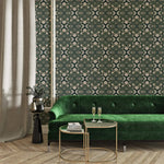 Intricate floral block print wallpaper, cream blooms on teal behind a green velvet sofa and gold tables