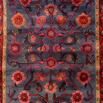 This image showcases an intricate pattern hand-tufted area rug featuring a beautiful floral design. The vintage rug, perfect for a large living room, displays vibrant red and orange flowers on a dark grey background, highlighting the elegance of wool rugs in living room spaces.