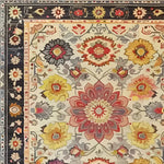 This vibrant area rug features an intricate floral design with a vintage charm, perfect for enhancing living room spaces. The hand-tufted wool rug showcases a rich tapestry of colors including reds, yellows, and blues, adding a touch of elegance to any living room decor.