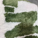 Close-up view of the Irregular 'Don't Be Shy' Area Rug, showcasing its unique green and white abstract pattern. Perfect for adding a modern touch to living room area rugs, this rug exemplifies stylish area rugs for living room decor.