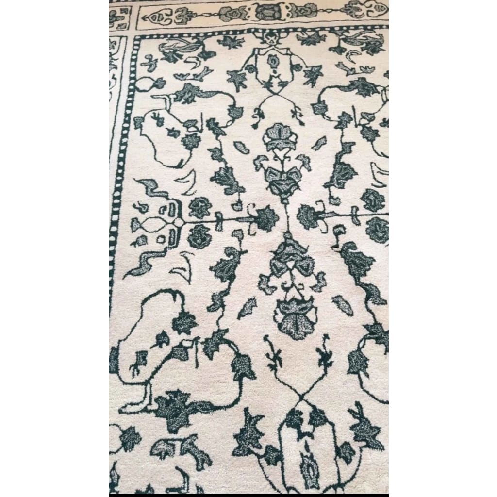 This image showcases the intricate design of the Ivory Whispers Hand Tufted Area Rug. Ideal for large living rooms, this 8x10 wool rug features a vintage-inspired floral pattern in soft ivory tones, perfect for adding a touch of elegance and comfort to your space.